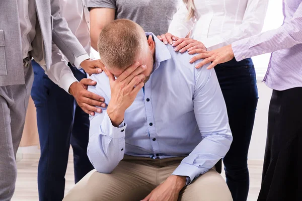 Group People Consoling Upset Man Sitting Chair — Stock Photo, Image