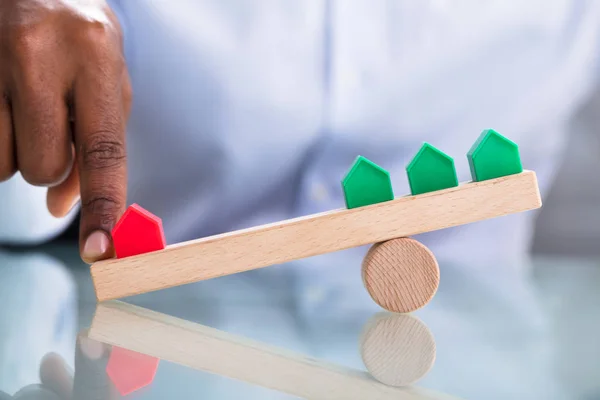 Mano Humana Que Equilibra Casa Miniatura Roja Verde Balancín Madera — Foto de Stock