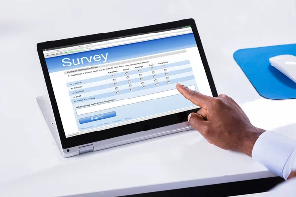 Close Businessman Hand Filling Survey Form Laptop White Desk — Stock Photo, Image