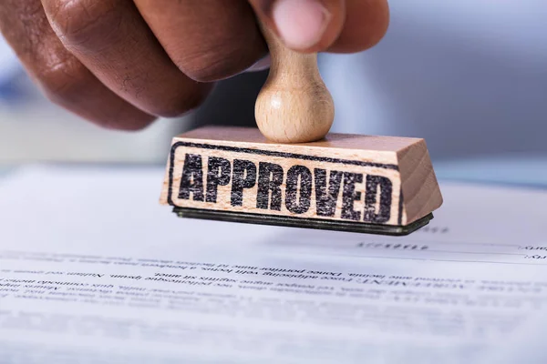 Close Hand Holding Wooden Stamp Defocused Document — Stock Photo, Image