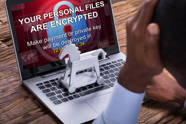 Крупный план обеспокоенного бизнесмена Зашифрованный текст на ноутбуке над деревянным столом
