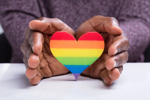 Close Man Hand Protecting Colorful Strip Heart White Desk — Stock Photo, Image