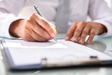 İşadamı'nın eli kalem ile sözleşme formu doldurma