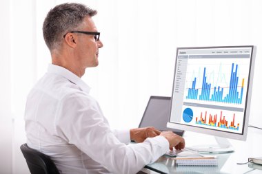 Bilgisayarda grafik arıyorum olgun bir işadamı yan görünüm