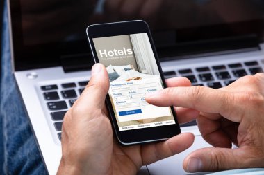 Bir adamın el rezervasyon otel Smartphone kullanarak Close-up