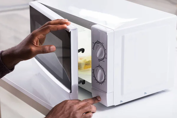 Primer Plano Mano Hombre Que Calienta Comida Horno Microondas —  Fotos de Stock