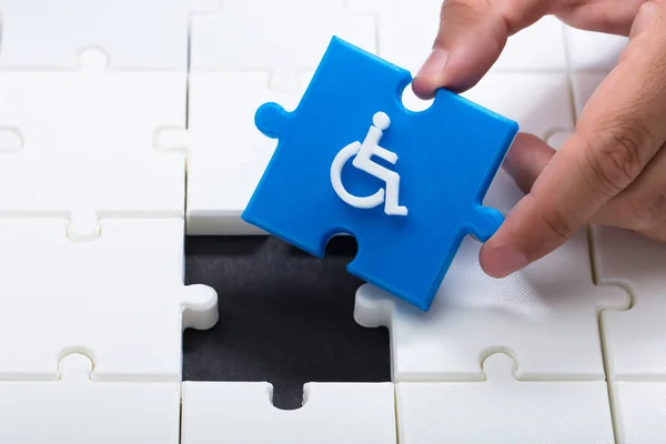 Menschliche Hand Löst Puzzle Mit Blauem Teil Mit Handicap Symbol — Stockfoto