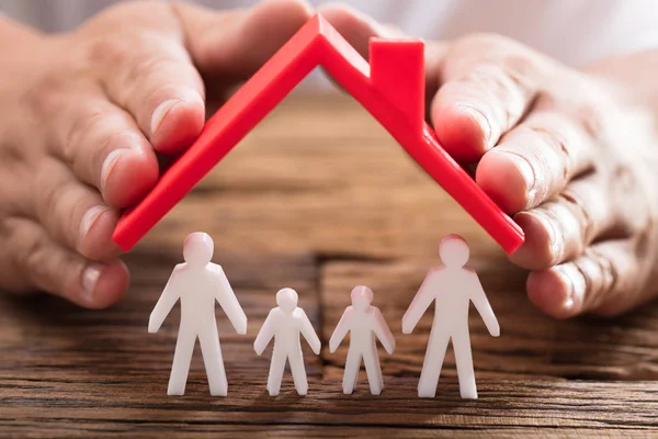 Mão Uma Pessoa Protegendo Figuras Familiares Com Telhado Vermelho Mesa — Fotografia de Stock