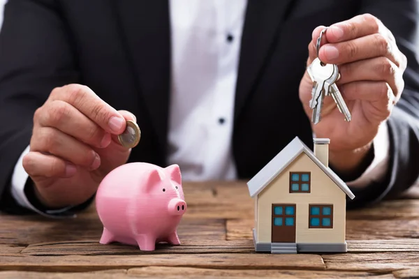 Ondernemer Hand Met Munt Sleutel Spaarpot Huis Houten Bureau — Stockfoto