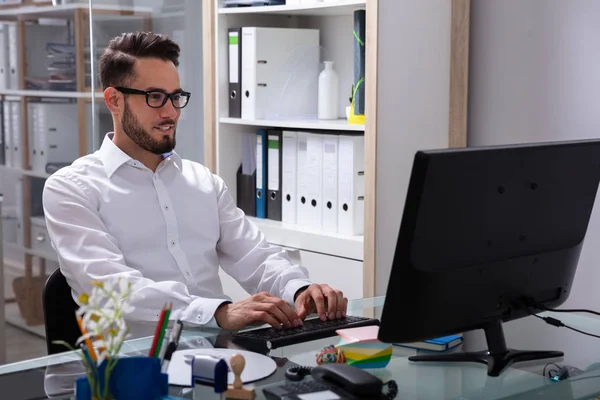 Улыбающийся Молодой Бизнесмен Работающий Компьютером Офисе — стоковое фото
