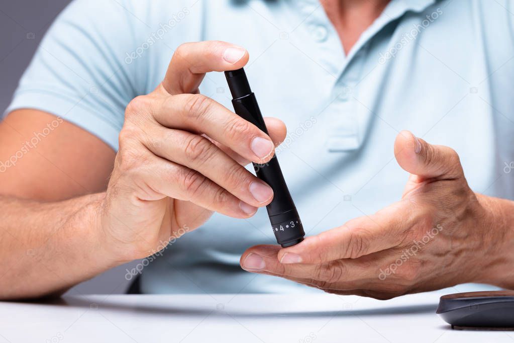 Close-up Of A Man's Hand Testing High Blood Sugar With Glucometer
