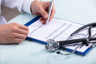 Belge üzerinde Resepsiyon stetoskop ile çalışan doktor