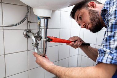 Genç erkek tesisatçı lavabo banyo ayarlanabilir anahtarı ile onarma