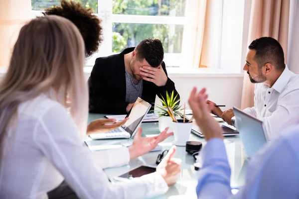 Businesspeople Blaming Depressed Young Male Colleague Office — Stock Photo, Image