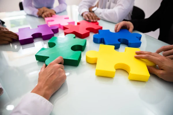 Group Businesspeople Colorful Solving Jigsaw Puzzle Desk Office — Stock Photo, Image