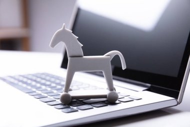 Close-up Of Trojan Horse Icon On Laptop Keypad clipart