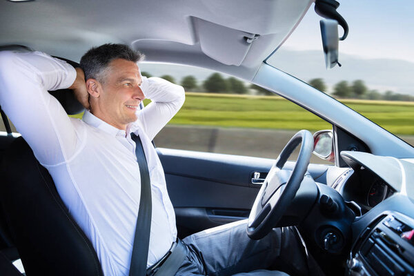 Side View Of A Relaxed Mature Man Sitting In Autonomous Self Driving Car