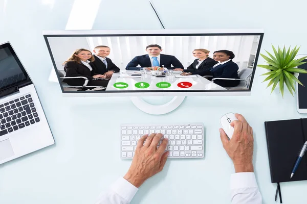 コンピューター上の同僚と実業家の手のビデオ会議の立面図 — ストック写真