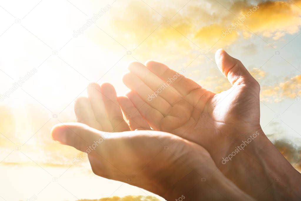 Close-up Of A Person Raising His Hand Up To The Sky In Sunlight