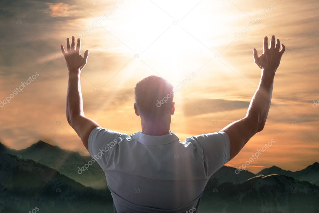 Man Raising His Arm In Front Of Mountain Landscape