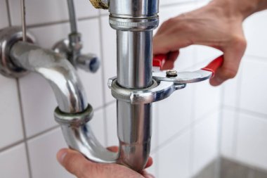 Yakın çekim bir tesisatçı 's el ile ayarlanabilir anahtarı lavabo tamiri