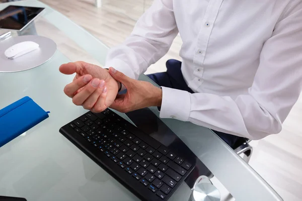 Businessman Holding Painful Wrist Glass Desk — Stock Photo, Image
