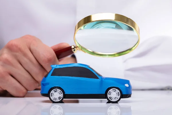 Mão Empresário Segurando Lupa Sobre Pequeno Carro Azul — Fotografia de Stock