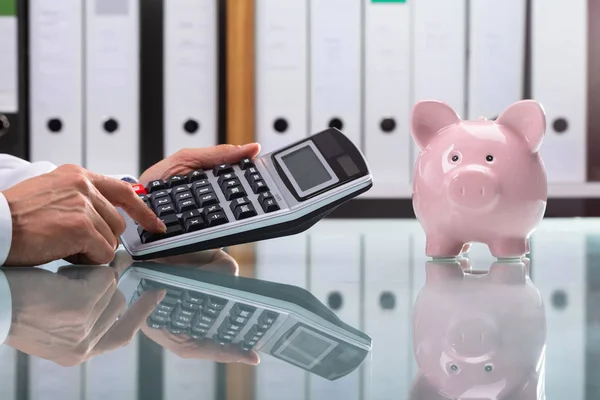 Close Mão Empresário Usando Calculadora Com Piggybank Mesa — Fotografia de Stock