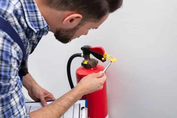 Jeune Technicien Masculin Vérification Symbole Sur Extincteur — Photo