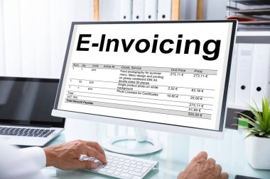 Mature Businessman Preparing E-invoicing Bill On Computer At Workplace clipart