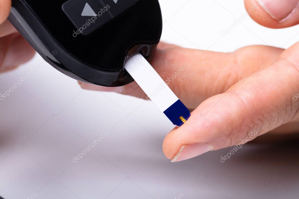 Close-up Of A Patient's Hand Measuring Blood Sugar With Glucometer