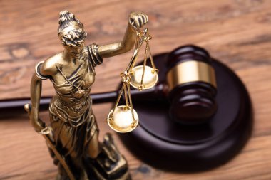 Statue Of Justice With Brown Gavel On Wooden Table clipart