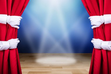 Two People Opening Red Stage Curtain With Three Spot Lights In Background clipart