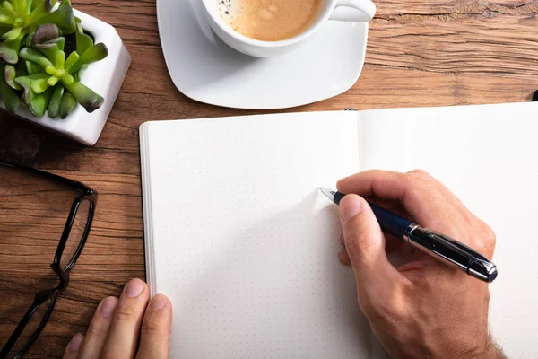 Close Van Een Persoon Schrijven Notebook Houten Bureau — Stockfoto