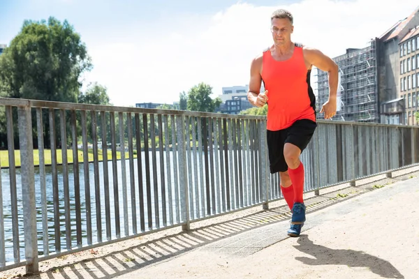 Foto Eines Älteren Athletischen Mannes Der Auf Dem Bürgersteig Läuft — Stockfoto