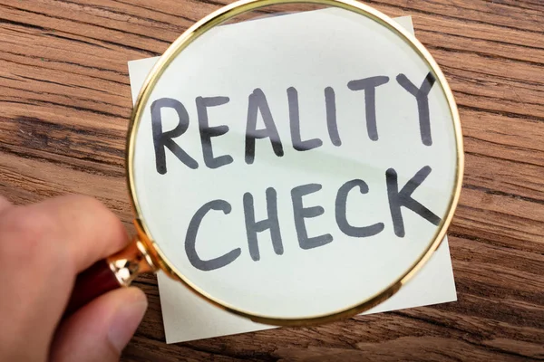 Close Van Iemands Hand Kijken Reality Check Word Door Vergrootglas — Stockfoto