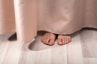 Close-up Of Person's Feet Behind The Curtain clipart