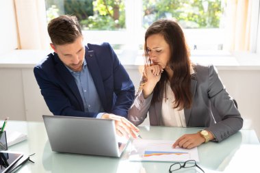 Ofis Masası dizüstü bilgisayar ile grafik analiz iki genç iş adamları