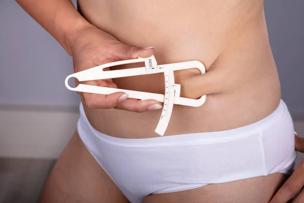 Tułów Widok Kobiecej Ręki Pomiaru Tłuszczu Brzucha Zacisku — Zdjęcie stockowe