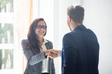 Eşi Office ile el sıkışan genç iş kadını gülümseyen