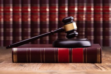 Yargıç tokmak ve hukuk kitabı ahşap masanın üzerinde duvarcı