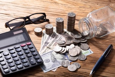 Sikke ve banknot ahşap masa hesap makinesi ile yığılmış