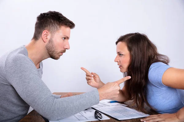 Pareja Joven Culpándose Mutuamente Con Documentos Escritorio Madera — Foto de Stock