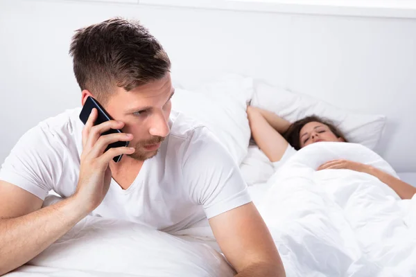 Young Man Talking Mobile Phone While Her Wife Sleeping Bed — Stock Photo, Image