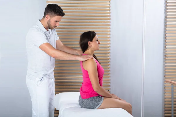 Mujer Joven Recibiendo Masaje Espalda Terapeuta Masculino Clínica —  Fotos de Stock