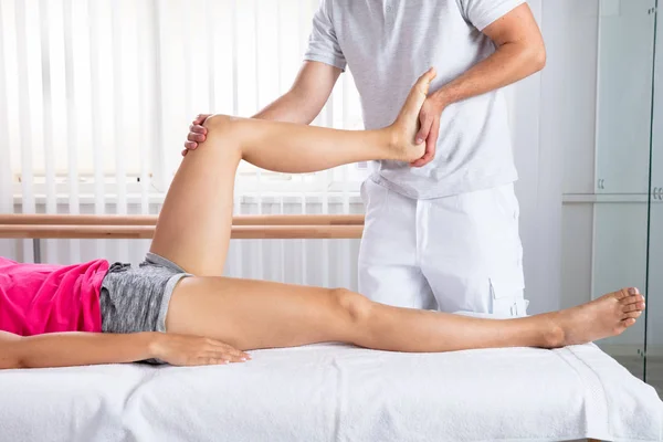 Mão Terapeuta Masculino Alongamento Perna Paciente Feminino Clínica — Fotografia de Stock