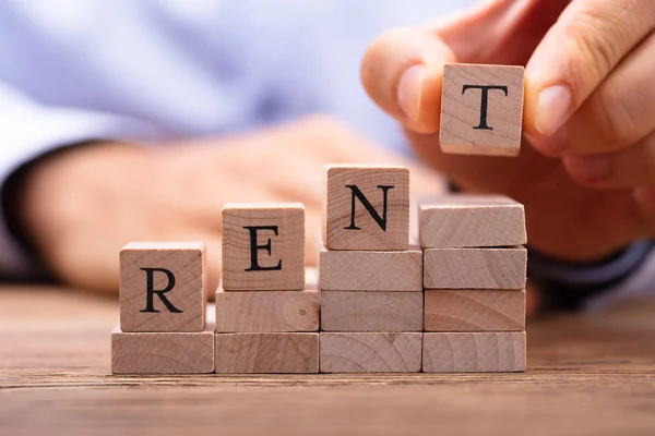 Person Hand Holding Wooden Blocks Placing Last Alphabet Word Rent — Stock Photo, Image