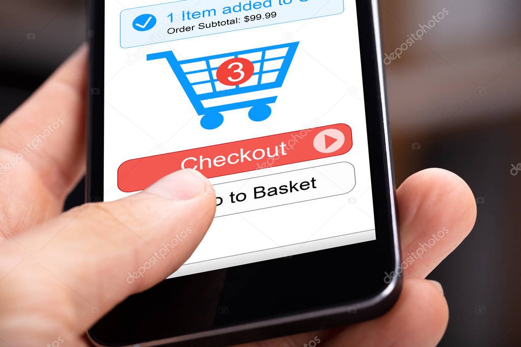 Human Hand Holding Mobile Phone With Online Shopping Application