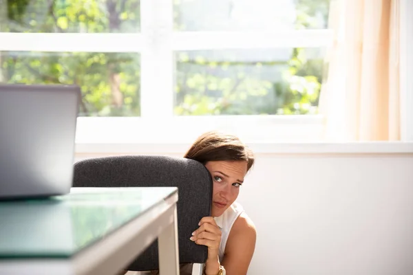 Mujer Negocios Joven Asustada Escondiéndose Detrás Silla Lugar Trabajo — Foto de Stock