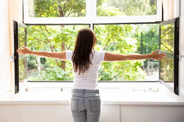 Rear View Woman Outstretching Her Arms Front Window — Stock Photo, Image